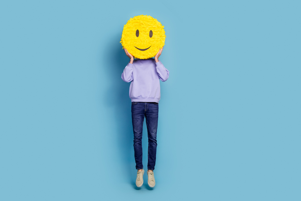 Full length body size view of attractive cheerful guy hippie jumping holding smiley isolated over bright blue color background